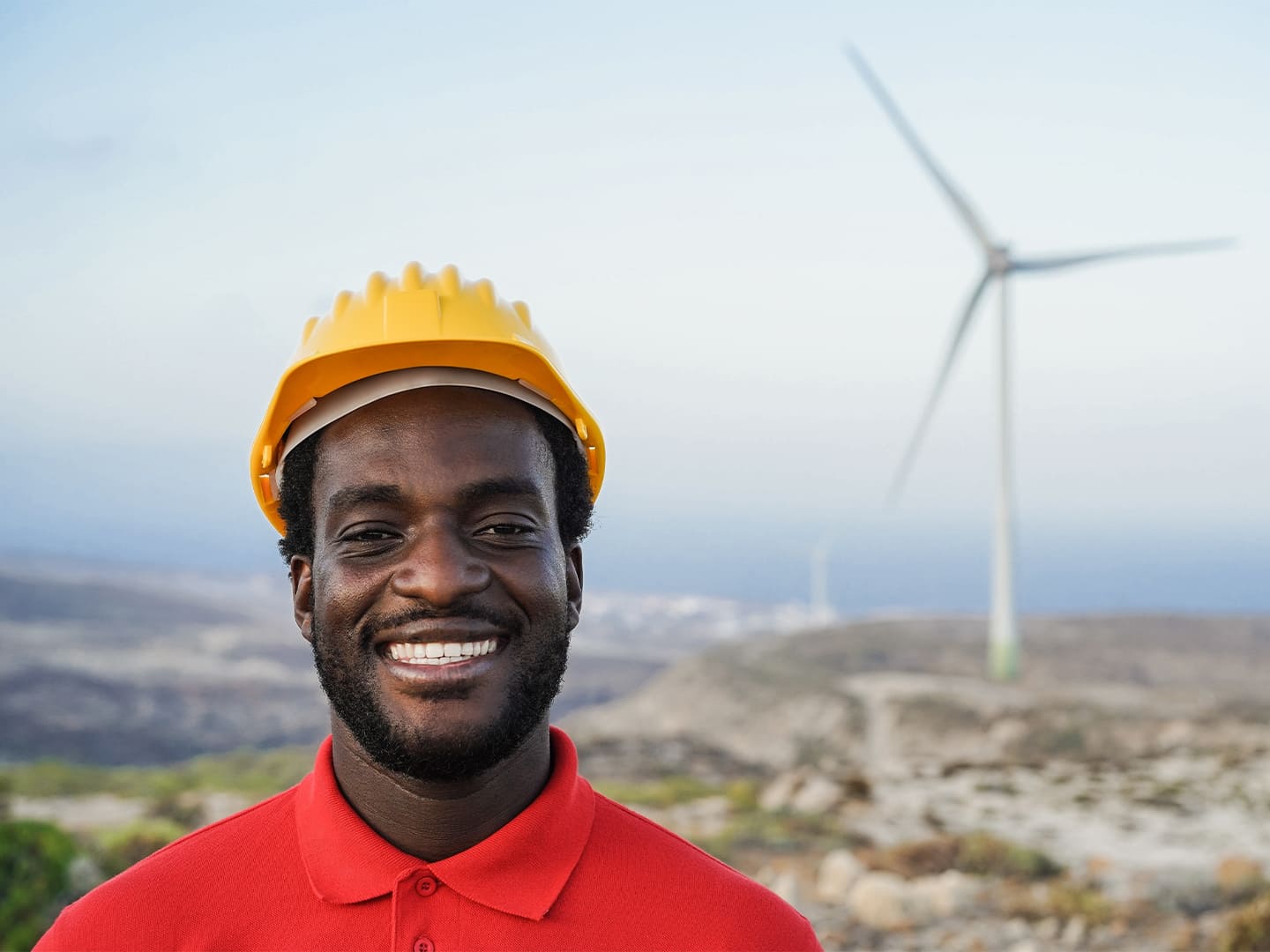 Homme devant une éolienne